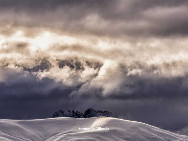 Snow-covered mountains under cloudy sky