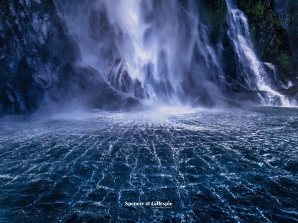 Majestic waterfall into a turbulent blue ocean.