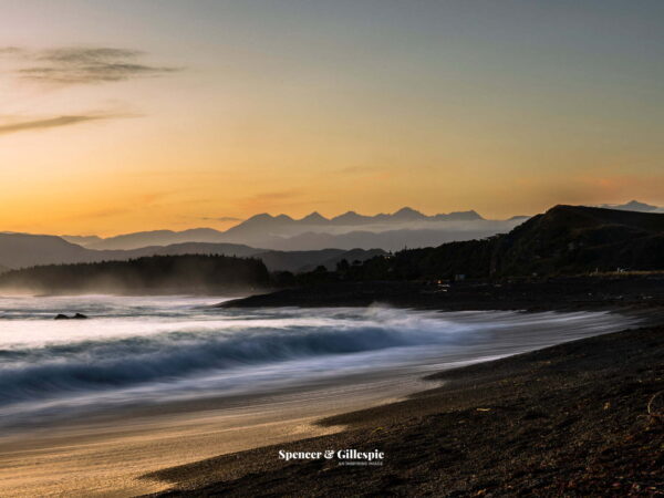New Zealand beach at sunset with mountains