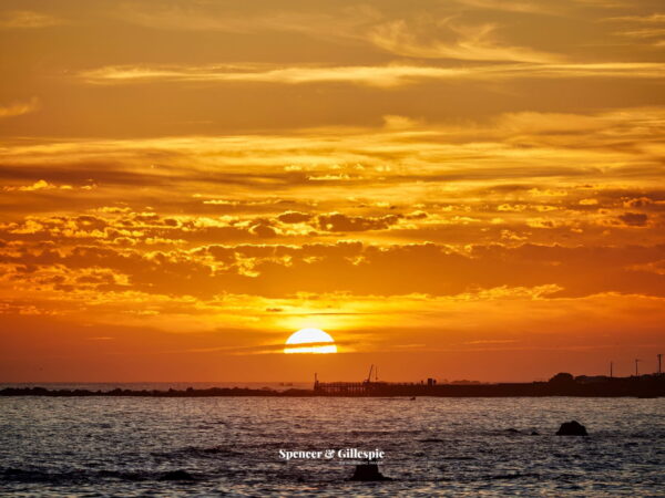 Golden sunrise over ocean horizon.