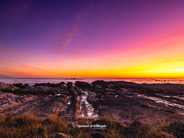 Sunset over rocky New Zealand coastline
