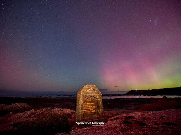 Aurora over New Zealand coastline at night
