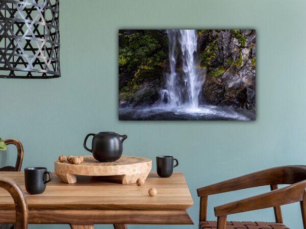 Dining room with waterfall painting on wall.