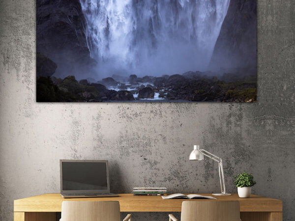 Office desk with waterfall artwork on wall.