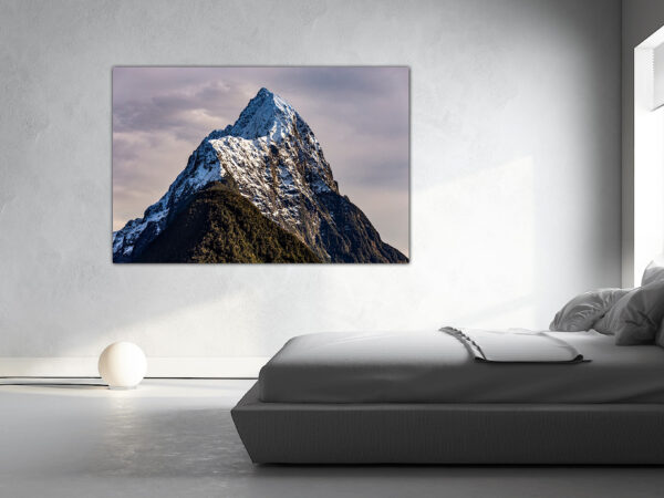 Bedroom with mountain art on wall.