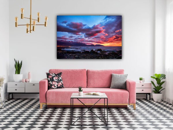Modern living room with pink sofa and ocean sunset painting.