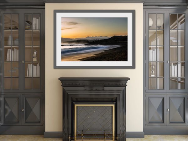 Living room with framed beach sunset photo.