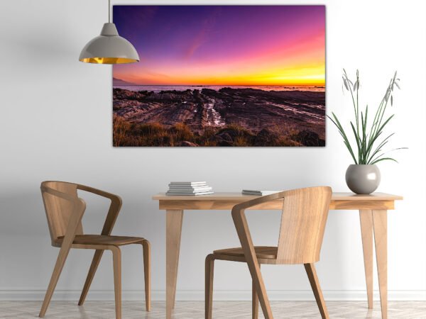 Dining area with coastal sunset painting
