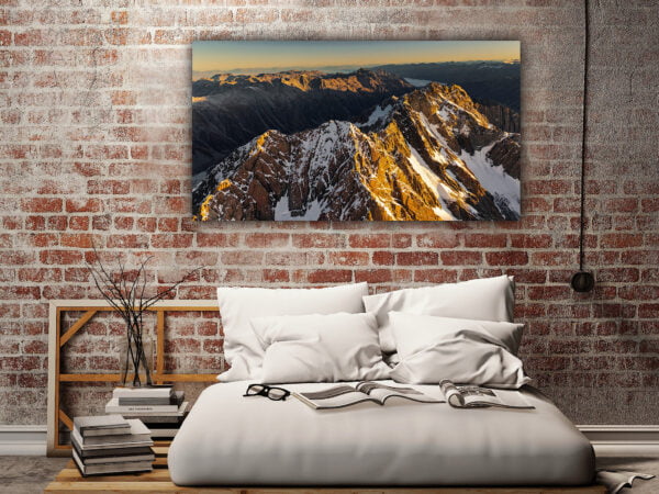 Loft bedroom with mountain painting on brick wall.