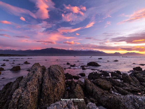 Sunset at rocky New Zealand coastline.