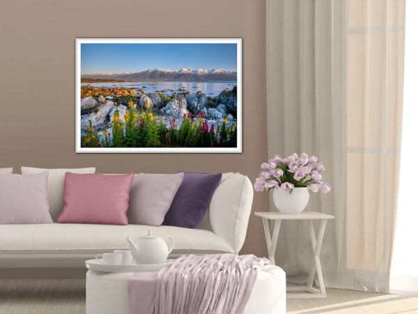 Stylish living room with landscape painting and flowers.