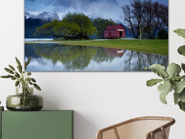 Framed nature photo above green cabinet and chair