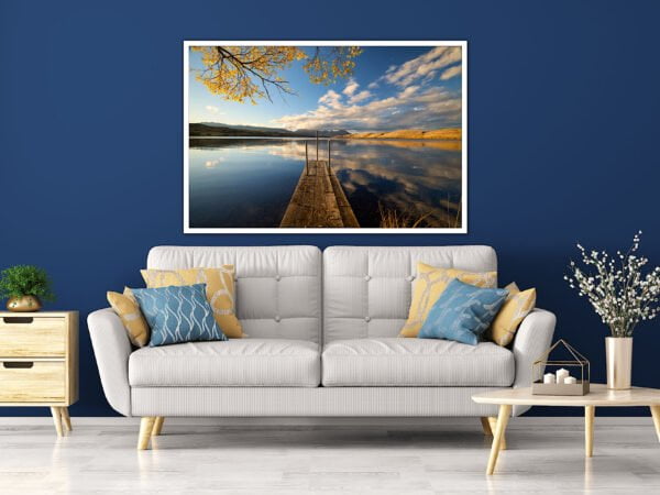 Modern living room with lake view artwork.